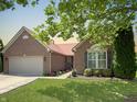 Charming brick home featuring an attached garage, a beautifully landscaped yard, and a welcoming walkway at 9302 N Bayland Dr, McCordsville, IN 46055