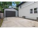 Side view of the home featuring a long concrete driveway and detached garage at 953 E 34Th St, Indianapolis, IN 46205