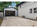 View of the home's detached garage with open door and concrete driveway at 953 E 34Th St, Indianapolis, IN 46205
