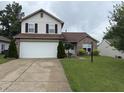 Two-story home featuring a two-car garage, well-kept lawn, brick and vinyl siding, and mature landscaping at 982 Ramsgate Rd, Greenwood, IN 46143