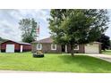 Ranch-style home with brick exterior, large front yard, and detached garage at 100 Justin Dr, Mooresville, IN 46158