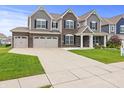 Charming two-story home with inviting front lawn, spacious driveway, and attached garage at 10811 Wild Orchard Ln, Indianapolis, IN 46239