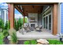 Covered outdoor patio features a stone fireplace and comfortable seating area at 12839 Bird Cage, Carmel, IN 46032