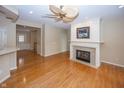 Cozy living room featuring a fireplace, hardwood floors, and a ceiling fan at 12880 Oxbridge Pl, Fishers, IN 46037