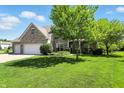 Well-manicured lawn complements this charming two-story brick home with a three-car garage at 13355 Freenza Ct, Carmel, IN 46074
