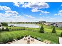 Expansive backyard featuring lush green lawn, mature trees, and a serene lake view in a desirable neighborhood at 14682 Braemar E Ave, Noblesville, IN 46062