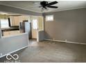 Cozy living room open to the kitchen with grey walls and a ceiling fan at 1610 Douglas Ln, Lebanon, IN 46052