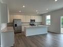 Bright kitchen features stainless steel appliances, an island, and a view to the backyard at 171 Ames Dr, Whiteland, IN 46184