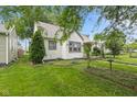 View of the house with vibrant green lawn, mature trees, and manicured landscaping at 1739 Caldwell Pl, Columbus, IN 47201