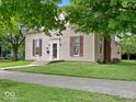 Side view of a two-story home with a well-manicured lawn and red brick chimney on a sunny day at 228 W Washington St, Shelbyville, IN 46176
