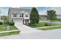 Inviting two-story home boasts lush landscaping, a driveway, and a combination of siding and brick at 2615 Pumpkin Patch Ln, Indianapolis, IN 46229