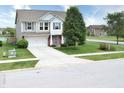 Inviting two-story home boasts lush landscaping, a driveway, and a combination of siding and brick at 2615 Pumpkin Patch Ln, Indianapolis, IN 46229