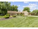 Charming single-story home featuring a well-manicured lawn, mature trees, and inviting curb appeal at 272 N Peterman Rd, Greenwood, IN 46142