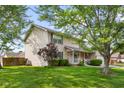 Well-maintained home featuring a charming porch, manicured lawn, and mature trees at 2872 N Prairie Stream Way, Columbus, IN 47203
