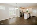 Bright dining area featuring luxury vinyl floors and views into a kitchen with stainless appliances and a kitchen island at 3626 N Capitol Ave, Indianapolis, IN 46208