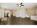 Spacious living room with dark vinyl flooring, natural light, and an open layout leading to the staircase at 3626 N Capitol Ave, Indianapolis, IN 46208