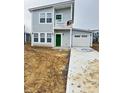 Stylish two-story home featuring gray siding, a bright green front door, and an attached garage at 3813 N Lawndale Ave, Indianapolis, IN 46254