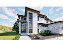 Contemporary home with stone and white exterior, black framed windows, and professionally landscaped front yard at 3925 Besbie Way, Bargersville, IN 46106