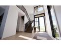 Bright foyer features a modern staircase, tall windows, and sleek finishes at 3925 Besbie Way, Bargersville, IN 46106