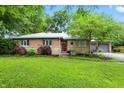Beautiful single-story brick home features mature trees, green lawn, and inviting curb appeal at 4340 Ashbourne Ln, Indianapolis, IN 46226