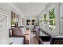 Bright sunroom with multiple windows, comfortable seating, and hanging floral arrangements at 4356 N College Ave, Indianapolis, IN 46205