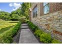 Stone walkway and lush greenery enhance the curb appeal of the home with manicured shrubs and blooming flowers at 4446 Lakeridge Dr, Indianapolis, IN 46234