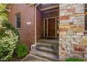Inviting front entrance features brick and stone accents, a wooden door, and manicured landscaping at 4446 Lakeridge Dr, Indianapolis, IN 46234