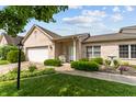 Inviting single-story brick home with lush landscaping and a cozy front porch at 564 Parkhurst Ct, Greenwood, IN 46142