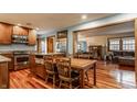 Open concept kitchen boasts wood cabinets, stainless steel appliances, granite countertops, and hardwood floors at 6295 N Olney St, Indianapolis, IN 46220