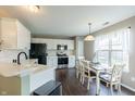 Bright kitchen with white cabinets, stainless appliances, and a dining area with natural light at 63 Longfellow Ln, Greenfield, IN 46140