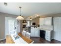 Open-concept kitchen offering white cabinets, black appliances, and views into the living area at 63 Longfellow Ln, Greenfield, IN 46140
