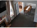 Elevated view of carpeted dining room with fireplace, large window and view into next room at 6524 Amick Way, Indianapolis, IN 46268