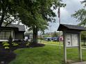 A shot of the common area with mature tree, lawn, American flag and playground at 7220 Village Pkwy Dr # 3, Indianapolis, IN 46254