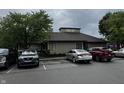 A view of the building's exterior with a cloudy sky, trees, and several parked cars at 7220 Village Pkwy Dr # 3, Indianapolis, IN 46254