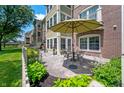 Charming outdoor patio with table and chairs, surrounded by lush landscaping and a white picket fence at 7601 Newport Bay Dr # 115, Indianapolis, IN 46240
