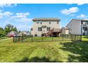 View of the back of the home with a black metal fence surrounding the large yard and a wood deck at 773 Bracknell Dr, Avon, IN 46123