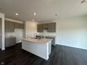 The open kitchen features an island with sink and seating, grey cabinets, and stainless steel appliances at 7909 Magnolia St, New Palestine, IN 46163