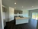 An open kitchen featuring a central island, neutral cabinets, stone countertops, and modern recessed lighting at 7909 Magnolia St, New Palestine, IN 46163