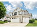 Attractive two-story home with a stone accent, three-car garage, and beautifully landscaped front yard on a sunny day at 8126 Kilborn Way, Avon, IN 46123