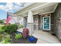 Inviting front porch with decorative stone columns, charming decor, and colorful plants enhancing curb appeal at 8126 Kilborn Way, Avon, IN 46123
