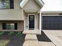 Home featuring a modern entrance with black door, green wreath, and dark mulch at 8277 N Waterford Dr, Columbus, IN 47201