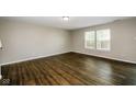 Bright living room with dark wood flooring, neutral-toned walls, and ample natural light from large windows at 8310 Becks Mill Ln, Indianapolis, IN 46113