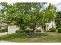 Lovely house with large tree, green lawn, and well-maintained landscaping at 8753 Champions Dr, Indianapolis, IN 46256