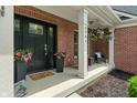 Inviting front porch with brickwork, flowers, and a cozy seating area perfect for relaxing at 8904 Carnation Dr, Noblesville, IN 46060