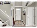 Inviting entryway with hardwood floors, a white front door, and a two-story ceiling at 9653 Cypress Way, Carmel, IN 46032