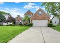 Charming brick home with well-kept lawn, tidy landscaping, and a two car garage at 9653 Cypress Way, Carmel, IN 46032