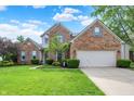 Beautiful brick home with manicured lawn, blue sky, and trimmed hedges at 9653 Cypress Way, Carmel, IN 46032