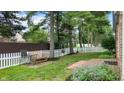 Spacious fenced in backyard with mature trees, bench, and swing set, creating a perfect place to relax at 1067 Acadia Ct, Indianapolis, IN 46217