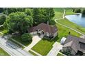 Aerial view of a brick home with manicured lawn near a pond and golf course, providing an outdoor lifestyle at 1326 Pebble Brook Dr, Noblesville, IN 46062