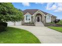 Charming brick home featuring a well-manicured lawn and a two-car garage with beautiful shrubbery at 1326 Pebble Brook Dr, Noblesville, IN 46062